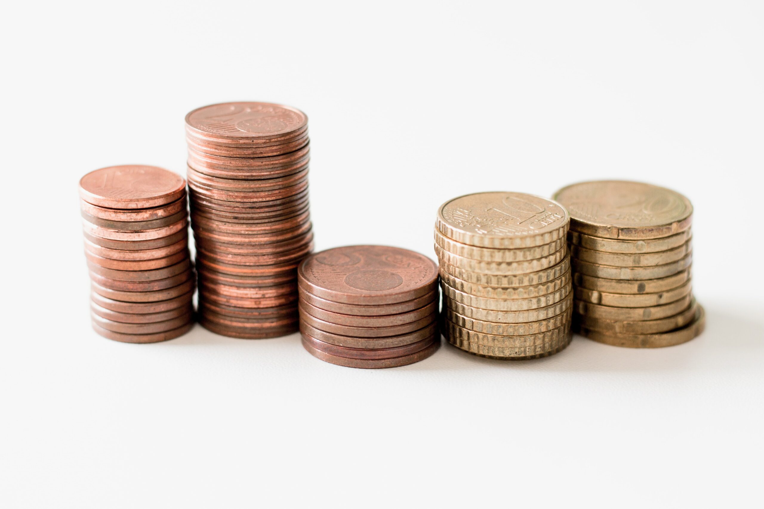 stacked round gold-colored coins on white surface